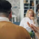 Un bărbat și o femeie stau de vorbă cu o psihologă într-un cabinet luminos